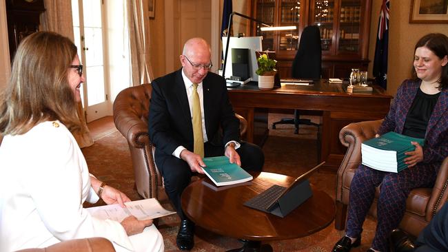 Governor-general David Hurley receives the final report of The Royal Commission into Aged Care Quality and Safety from Commissioner Lynelle Briggs (left) and Acting Official Secretary Sara Samios, with Commission Chair Tony Pagone joining via video link, at Admiralty House in Sydney, Friday, February 26, 2021. (AAP Image/Dan Himbrechts)