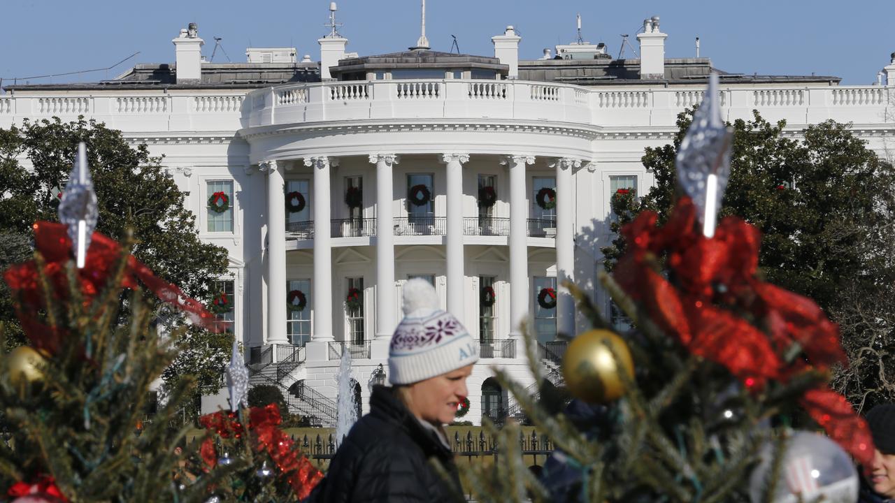 Visitors look over holiday decorations in front of the White House on December 18, 2019 in Washington. Picture: /Steve Helber.