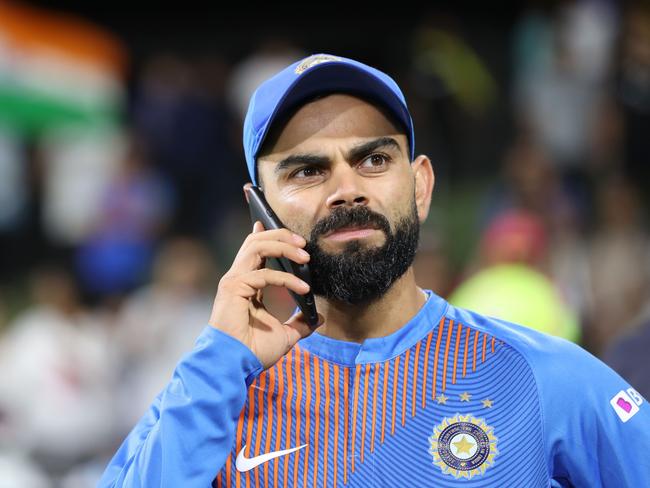 Indian captain Virat Kohli speaks on a phone after winning the fifth Twenty20 cricket match between New Zealand and India at the Bay Oval in Mount Maunganui on February 2, 2020. (Photo by MICHAEL BRADLEY / AFP)