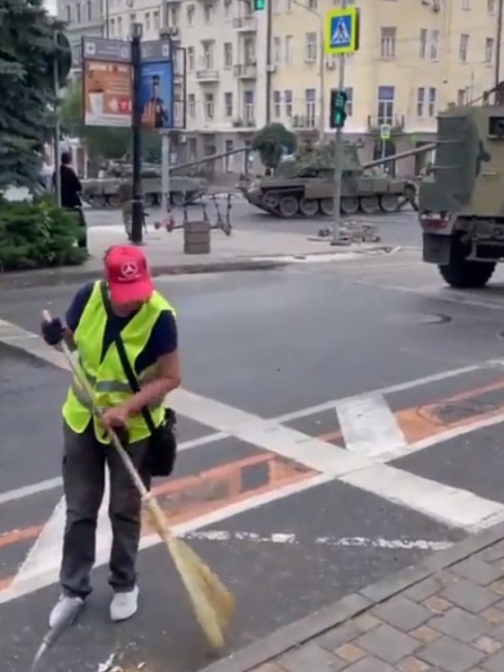 Cleaning — while tanks roll past.