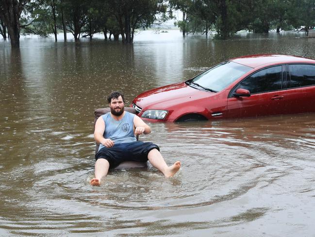 Allan Lavandar sits on a floating chair in floodwaters at Church Street in Windsor. Picture: John Feder