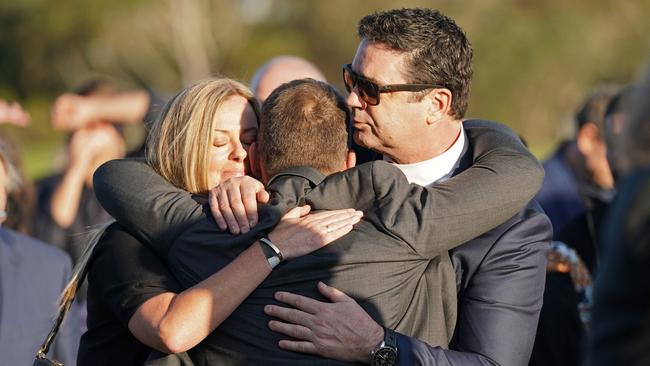 Nicky Brownless and Garry Lyon embrace Alastair Clarkson at the service. Picture: AAP Image/Scott Barbour