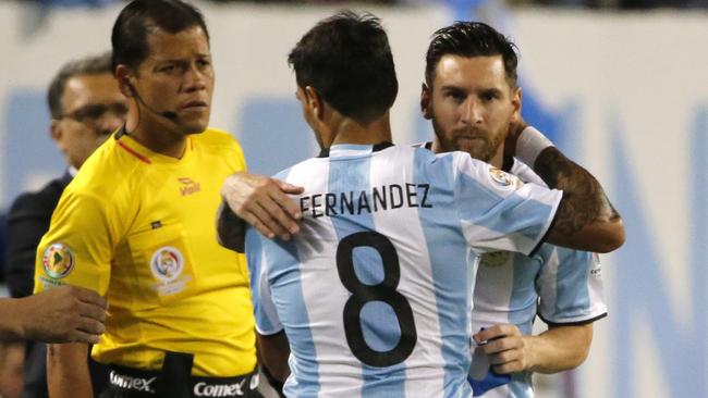 Argentina's Augusto Fernandez (8) hugs Argentina's Lionel Messi as he is substituted.