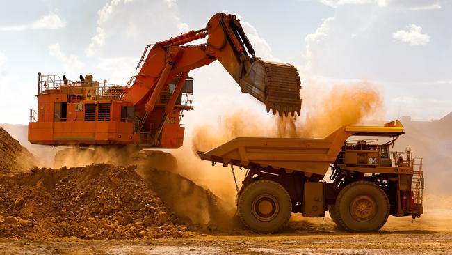 A haul truck is loaded by a digger with material from the pit at Rio Tinto Group's West Angelas iron ore mine in Pilbara, Australia, on Sunday, Feb. 19, 2012. Rio Tinto Group, the world's second-biggest iron ore exporter, will spend $518 million on the first driverless long-distance trains to haul the commodity from its Western Australia mines to ports, boosting efficiency. Photographer: Ian Waldie/Bloomberg via Getty Images