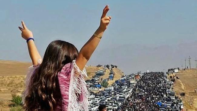 A young woman defies the authorities as thousands make their way to pay tribute to Mahsa Amini on Wednesday. Picture: UGC via AFP