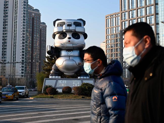 People walk past a giant panda installation at an intersection in Beijing. Picture: Jade Gao / AFP