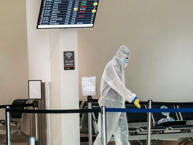 PERTH, AUSTRALIA  - NewsWire Photos DECEMBER 18, 2020: Cleaners clean handrails after Jet Star Passengers came through the wrong gate arriving from Sydney after Western Australia initiated a hard border with NSW in the wake of fresh Covid cases. Picture: NCA NewsWire / Tony McDonough