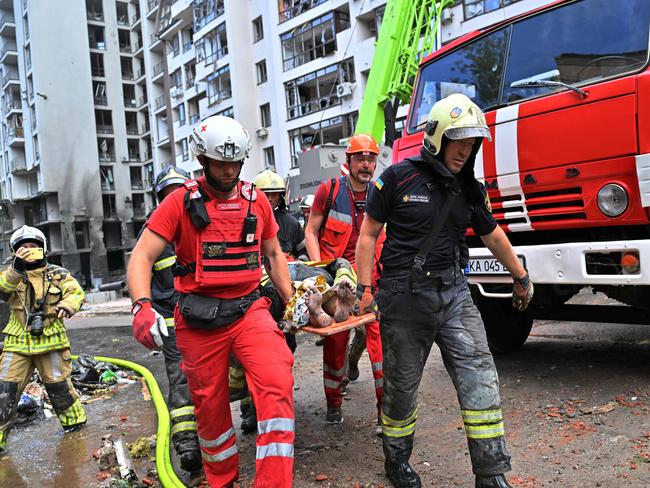 Ukrainian rescuers carry a wounded woman from a residential building destroyed by Russian missiles in Kyiv. Picture: AFP