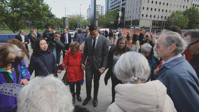 Israel Folau joins in prayer with supporters before heading into court. Picture: David Geraghty