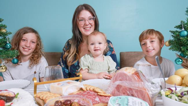 Jess Burnage with kids, Damien Curtis, 11, Lincoln Burnage, 7, and Spencer Burnage, 16 months, with their Christmas feast with items from Woolworths’ $100 menu. Picture: Ben Clark