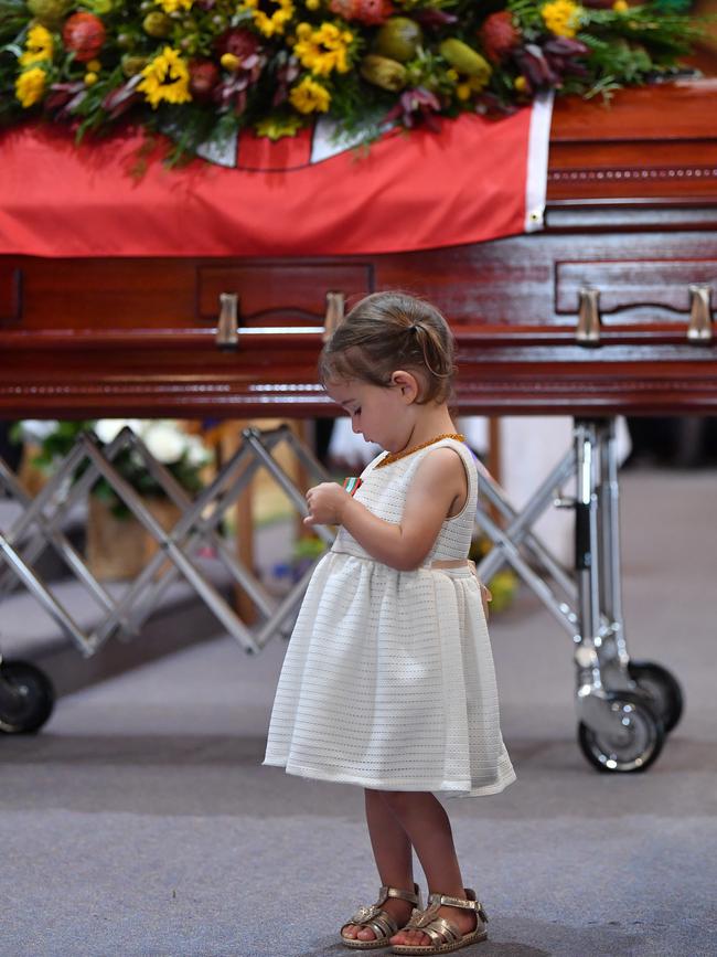 Charlotte O'Dwyer looks at the service medal presented to her by RFS Commissioner Shane Fitzsimmons during the funeral. Picture: AAP Image/Dean Lewins