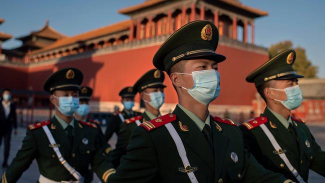 Paramilitary police officers wearing face masks march outside the Forbidden City in Beijing. Picture: AFP