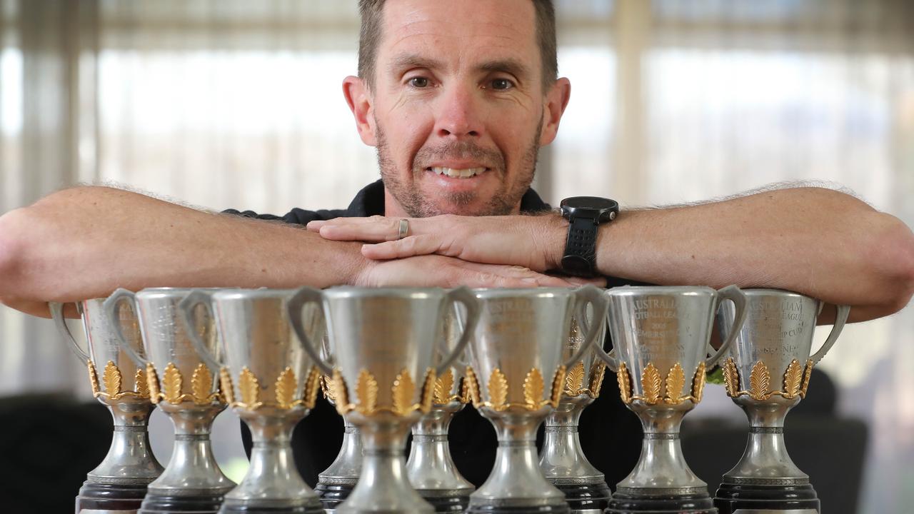 Former AFL boundary umpire Darren Wilson with the 12 replica premiership cups he was awarded for officiating in AFL grandfinals. Picture: Dean Martin