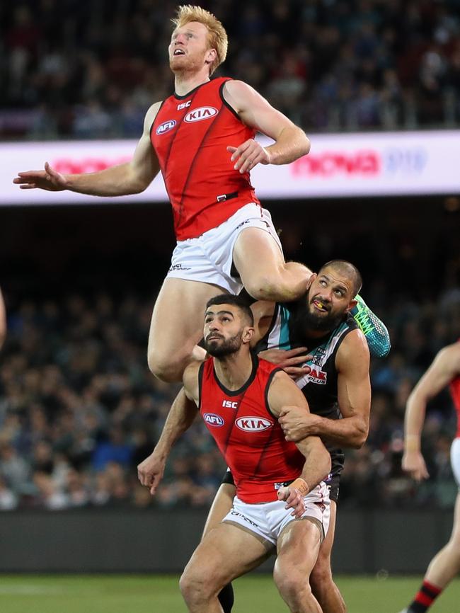 Essendon’s Aaron Francis flies for the mark over Bombers Adam Saad and Power’s Paddy Ryder at Adelaide Oval. 