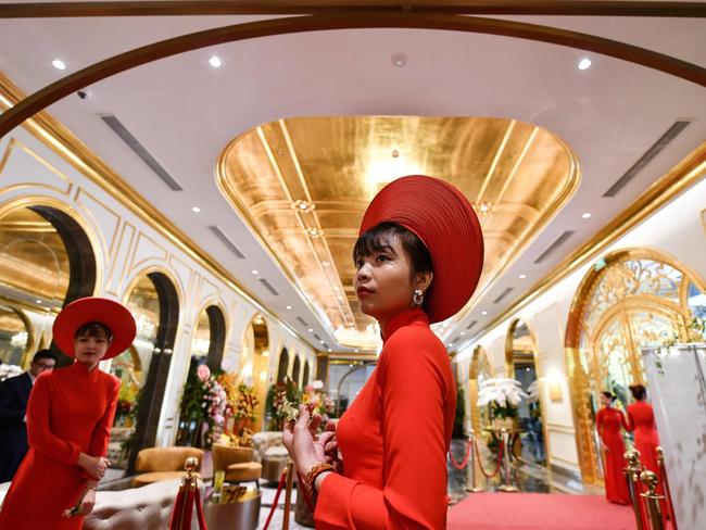 Staff wait to welcome guests in the lobby of the newly-inaugurated Hanoi Golden Lake hotel, the world's first gold-plated hotel, in Hanoi on July 2, 2020. (Photo by Manan VATSYAYANA / AFP)