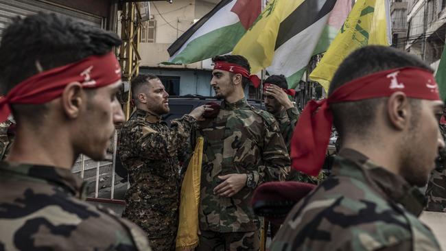 Hezbollah unit chief helps a Hezbollah supporter to hold his beret with the should strip within the area where the coffin will be honoured moments before the beginning of the funeral of a Hezbollah militant killed by IDF in southern Lebanon on October 23, 2023 in Beirut, Lebanon. Picture: Manu Brabo/Getty Images