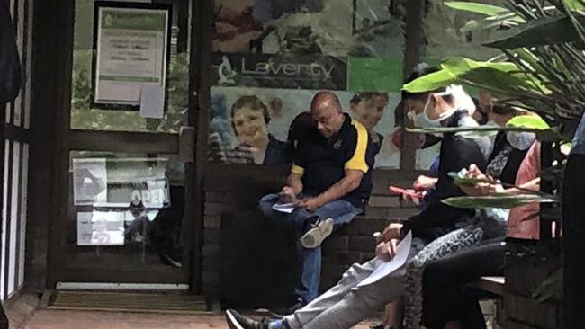 Residents sitting outside the Laverty Pathology lab at Bankstown on Tuesday. Picture: Lawrence Machado