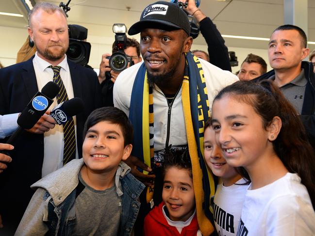 TOPSHOT - Usain Bolt poses for pictures with fans upon arrival at Sydney international airport on August 18, 2018. - Bolt, 31-year-old eight-time Olympic champion, arrived to start training with the A-League club Central Coast Mariners. (Photo by Saeed KHAN / AFP)