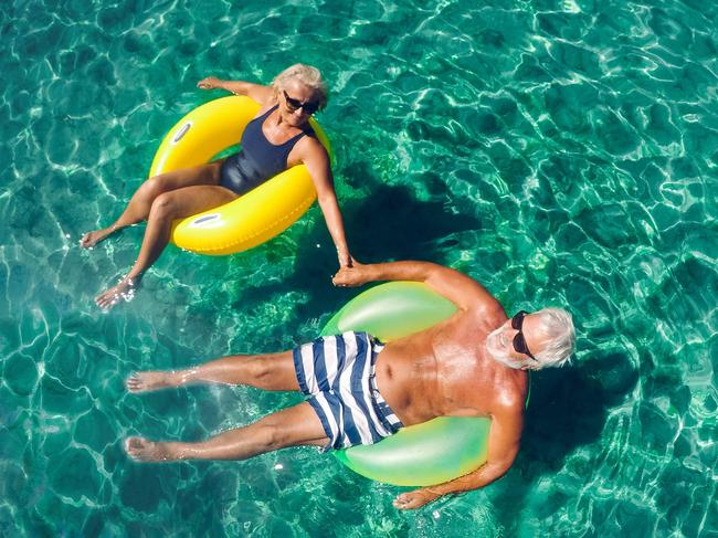 ESCAPE: Advice Old Insurance, Sarah Nicholson.  Photo of a senior couple floating in the ocean in an inflatable rings and enjoying the best years of their lives . Picture: iStock