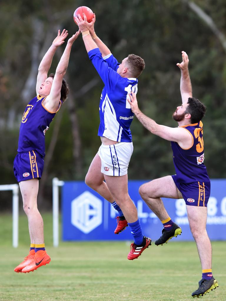 Essendon District: Coburg District’s coach Tom Gleeson takes a strong mark against Jacana opponents Tom Butler and Dean Weaver. Picture: Steve Tanner