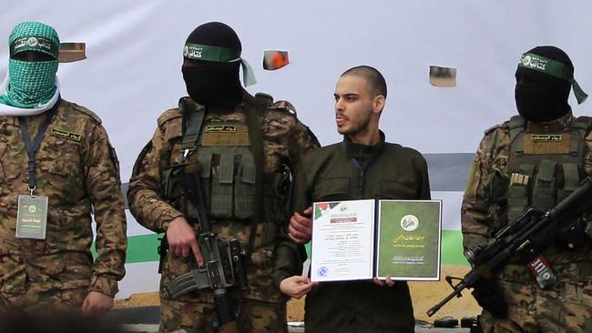 TOPSHOT - Palestinian Hamas militants parade three newly-released Israeli hostages on stage in Nuseirat in the central Gaza Strip, as part of the seventh hostage-prisoner release on February 22, 2025. (Photo by Eyad BABA / AFP)