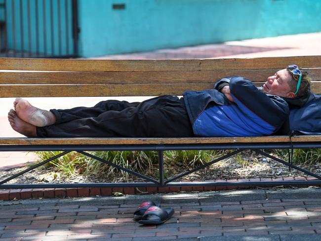 A man naps on a bench in Dandenong Mall. Picture: Penny Stephens