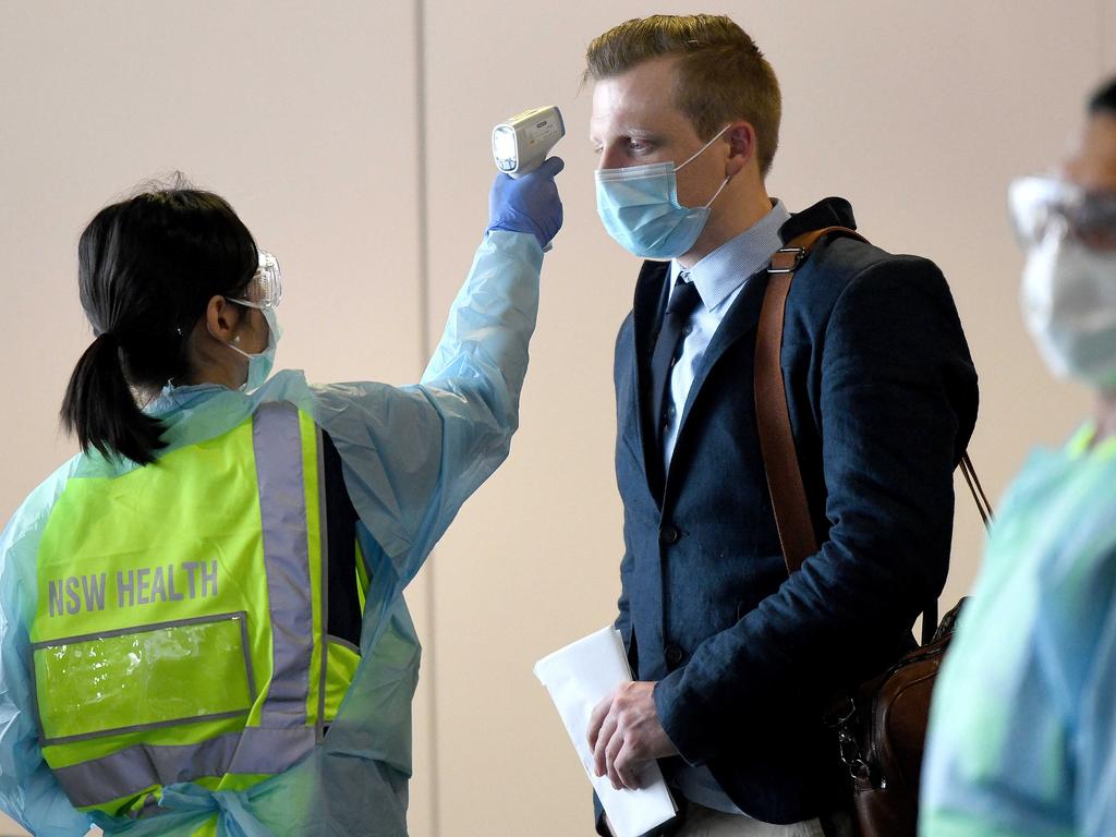 NSW health workers dressed in Personal Protective Equipment (PPE) are seen screening passengers at Sydney Airport. Picture: NCA NewsWire / Bianca De Marchi