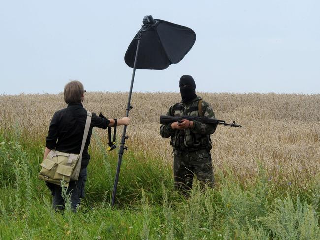 A masked armed separatist militant poses for a photographer near the site of the crash of a Malaysia Airlines crash. Picture: AFP/Dominique Faget
