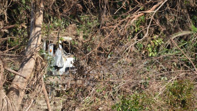 The remnants of a truck lay across the river from Wujal Wujal amid fallen trees. Picture: Bronwyn Farr