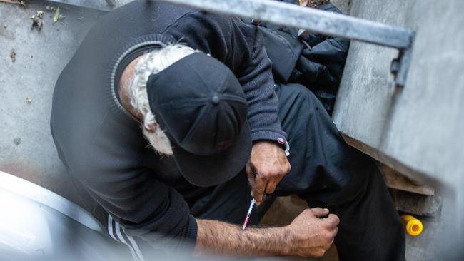 A man is seen injecting in a carpark next to North Richmond Community Health this week. Picture: Sarah Matray