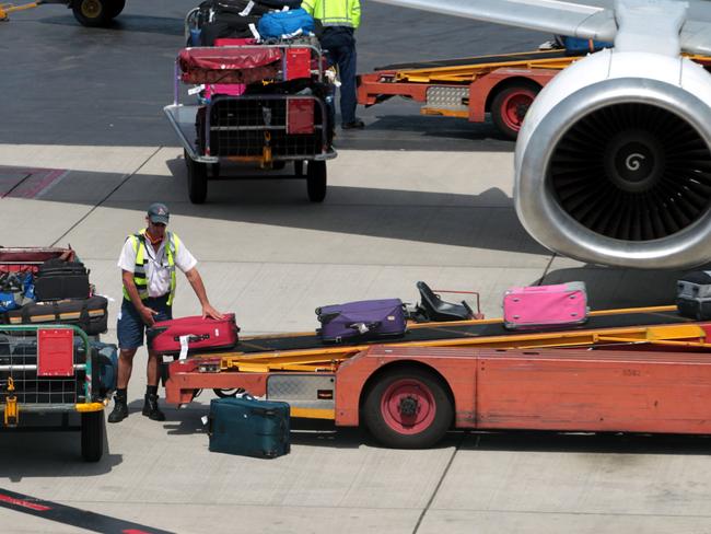 A baggage handler loads bags onto the first Qantas flight to leave Adelaide Airport after services resumed 31/10/2011.