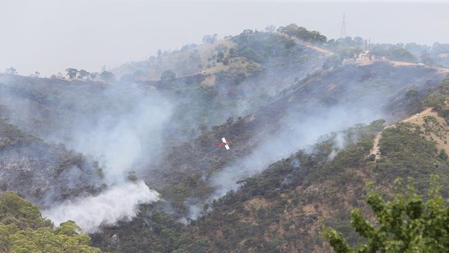 Water planes and Helicopters battle the bushfire at Montacute in the Adelaide Hills, seen from the Lower North Road, Highbury, SA. Picture Emma Brasier