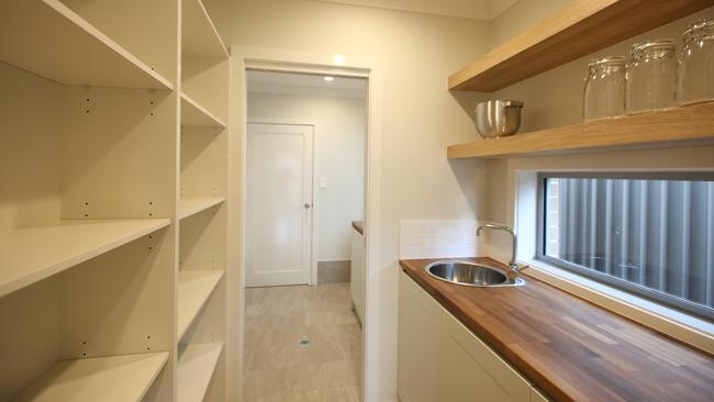 The butler’s pantry adjacent to the laundry provides a through way from the garage.