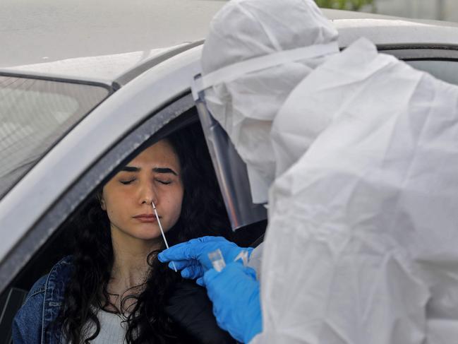 A paramedic tests a woman for the virus. Picture: AFP