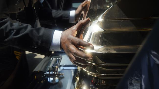 The hands of the funeral home team push the casket of George Floyd into the hearse after the funeral service at The Fountain of Praise church in Houston.