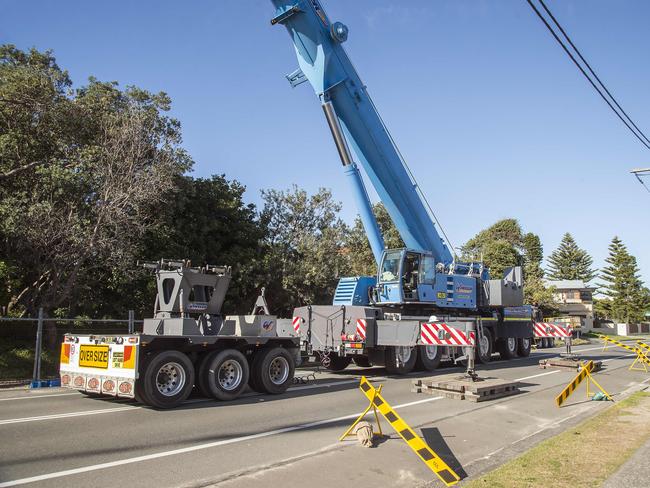 A massive crane prepares to move rock bags to form a break wall after erosion from heavy seas have left many waterfront Wamberal homes teetering on the breach of collapse. (NCA NEWSWIRE / Troy Snook)