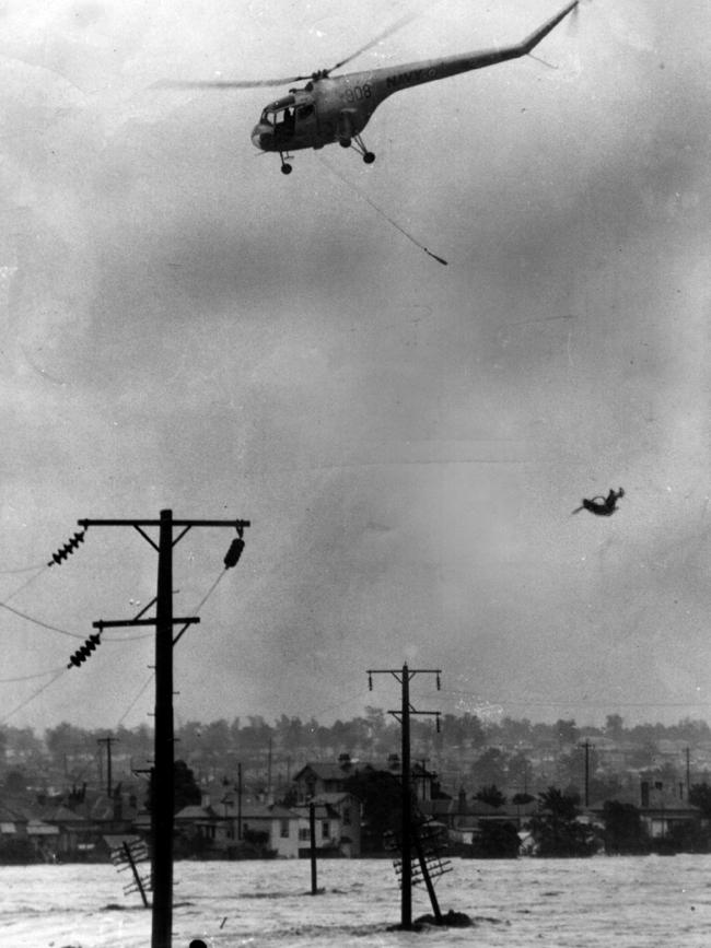 A Navy rescue helicopter drops a swimmer from the waters of the Maitland floods moments after picking him up. Picture: News Ltd