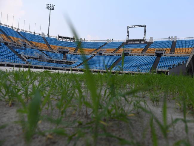 Grass is growing through the sand at the 2008 Olympic beach volleyball stadium.