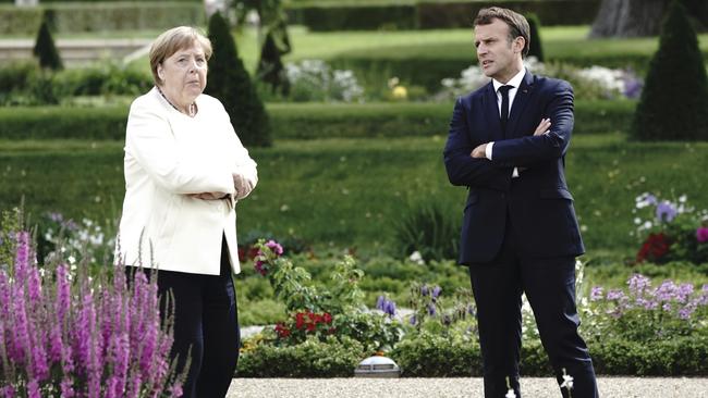 Angela Merkel, left and Emmanuel Macron talk in the garden of Meseberg Castle. Picture: AP