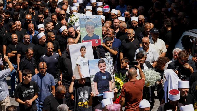 TOPSHOT - Elders and mourners carry the coffin of Guevara Ibrahim, 11, killed in a reported strike from Lebanon two days earlier, during his funeral in the Druze town of Majdal Shams in the Israeli-annexed Golan on July 29, 2024. Ibrahim was initially reported missing but has later been confirmed dead, while 11 others killed were laid to rest on July 28 in the Druze Arab town, hit a day earlier in a strike blamed by Israel on Lebanon's Hezbollah group that denied responsibility, though it claimed attacks on Israeli military positions that day. (Photo by Jalaa MAREY / AFP)