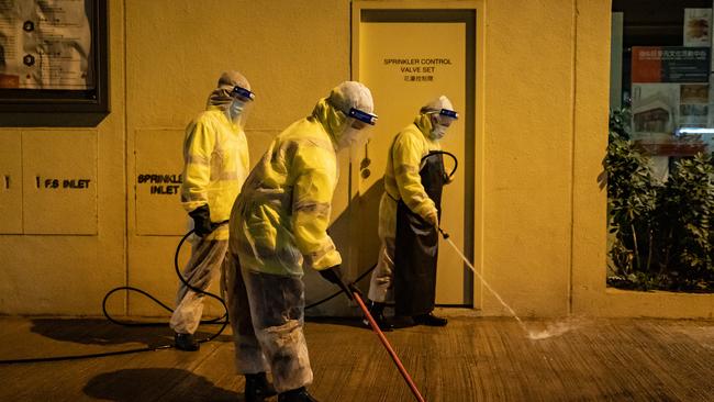 Workers wearing personal protective equipment clean the streets ahead of a lock down in part of the Jordan district in Hong Kong, China. Picture: Getty Images