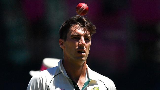 A tired looking Pat Cummins tosses the ball as he prepares to bowl on day five.