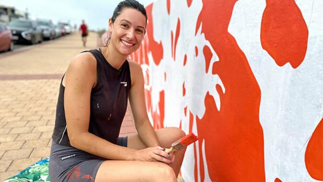 Local artist Alex Bellas painting the mural along the Glenelg Esplanade, which caused a stir among local residents. Picture: City of Holdfast Bay