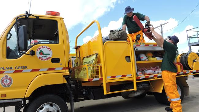 LOADING UP: Vic Axiak (on truck) and his son Sam load equipment onto a Rural Fire Service Queensland truck prior to departing Mackay for Biloela.