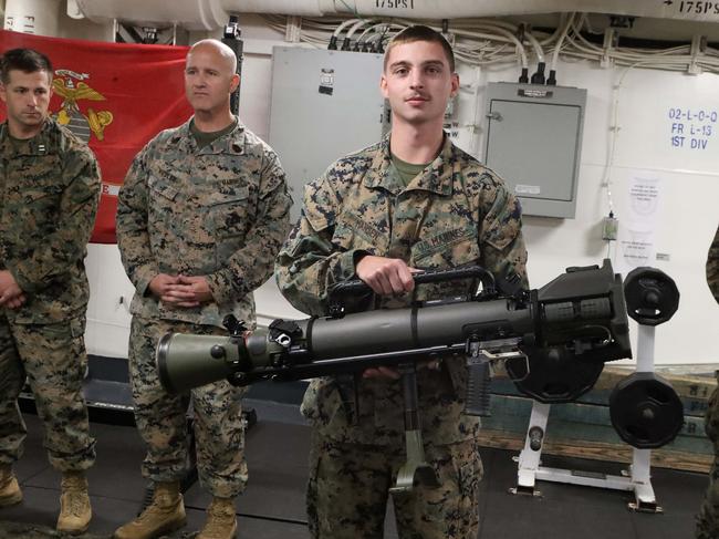 Some US Marines assigned to the USS America explaining some of their weapons. Picture: Liam Kidston