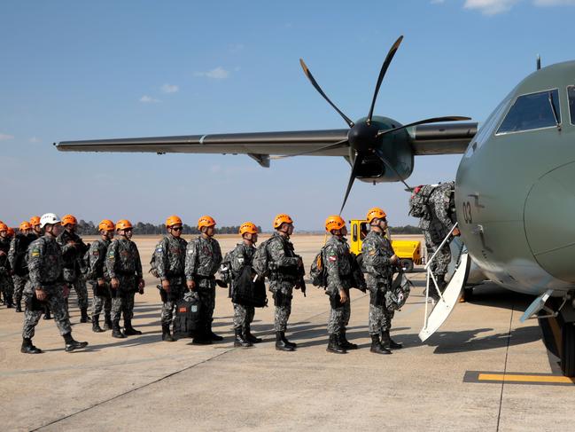 National Force military firefighters stand in line to board a plane to help fight fires in the Amazon rainforest. Picture: AFP