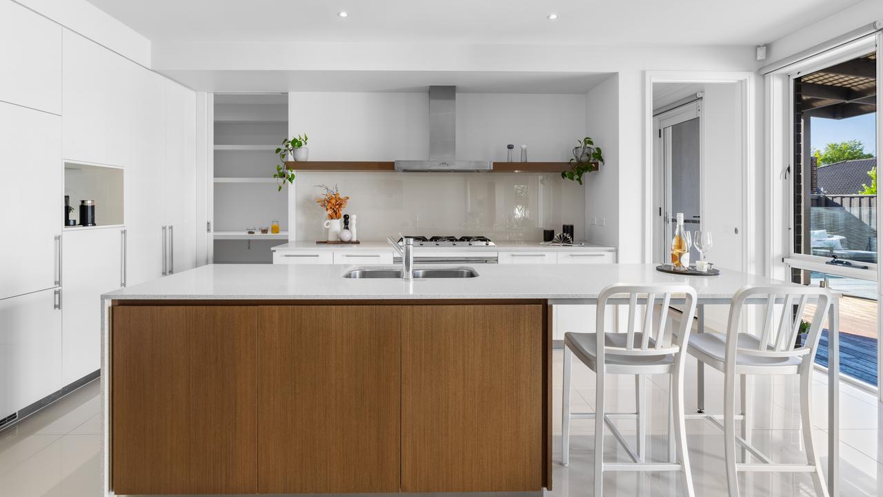 There are stone benchtops, Smeg appliances, integrated fridge and freezer, a Bosch dishwasher, walk-in pantry and island bench with breakfast table in the kitchen.