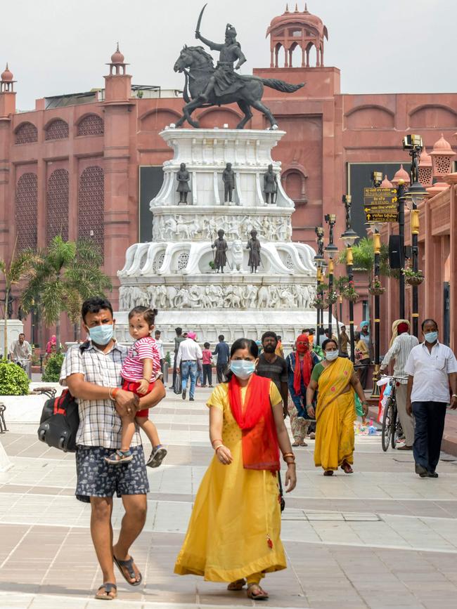 People walk at the Maharaja Ranjit Singh statue square in Amritsar, India. Picture: AFP