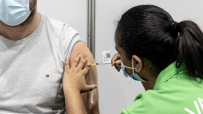 Rhys Barnes gets a Pfizer vaccination from enrolled nurse Maria Mathews at the Brisbane Convention and Exhibition centre vaccination hub. Picture: NCA NewsWire / Sarah Marshall