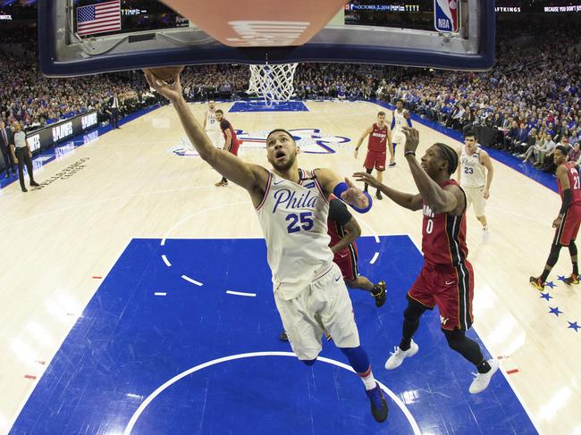 In this photo taken with a fisheye lens, Philadelphia 76ers' Ben Simmons, left, of Australia, shoots as he gets past Miami Heat's Josh Richardson, right, during the first half in Game 2 of a first-round NBA basketball playoff series, Monday, April 16, 2018, in Philadelphia. The Heat won 113-103. (AP Photo/Chris Szagola)